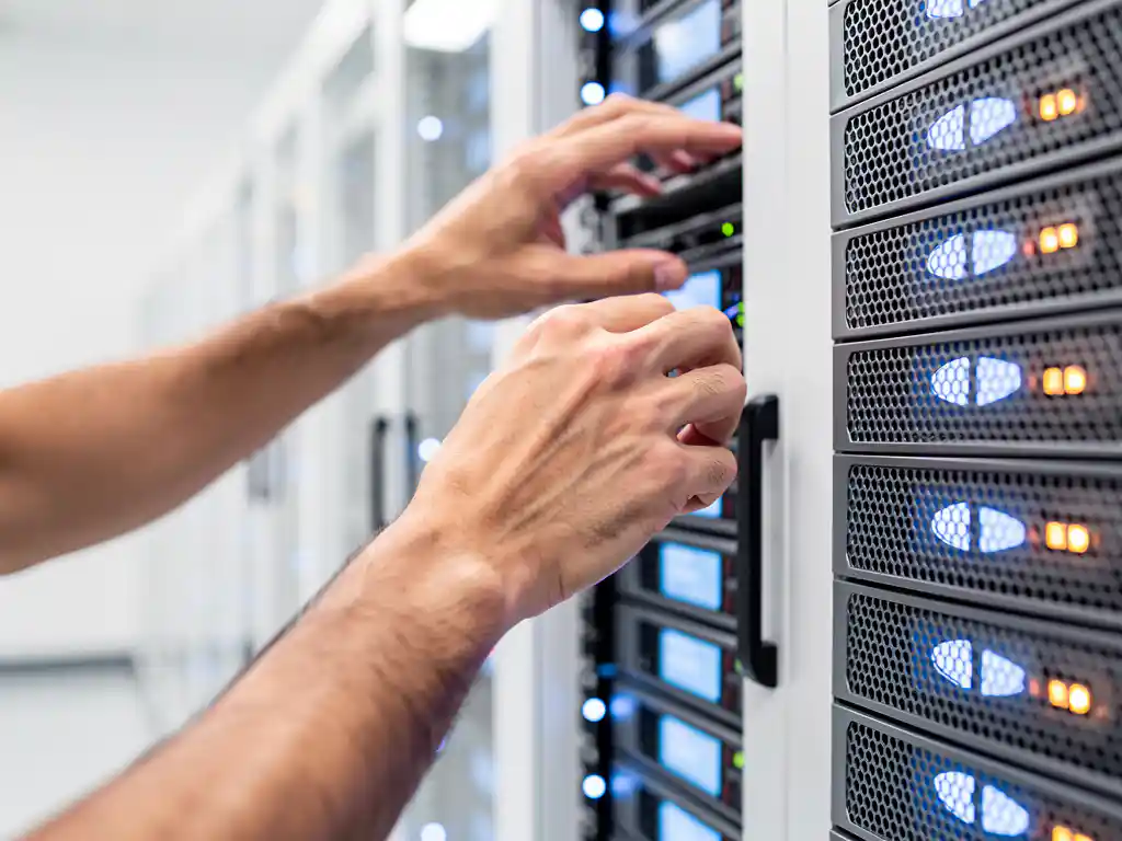 IT-technicus past serverrackcomponenten aan in wit datacenter met blauwe en amberkleurige statuslampjes